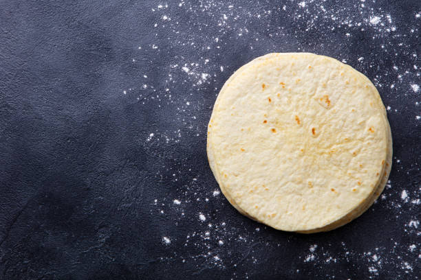 istock Tortillas, flat breads on dark grey background. Copy space. Top view. 1204165117