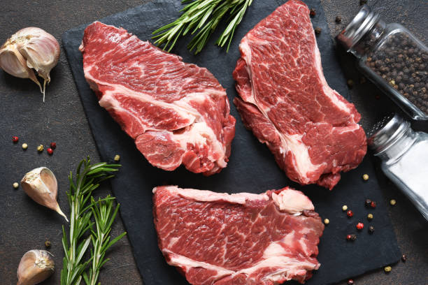 istock Raw marbled beef steak on a stone board. Spices, dishes. Top view flat lay with copy space. 1204165131