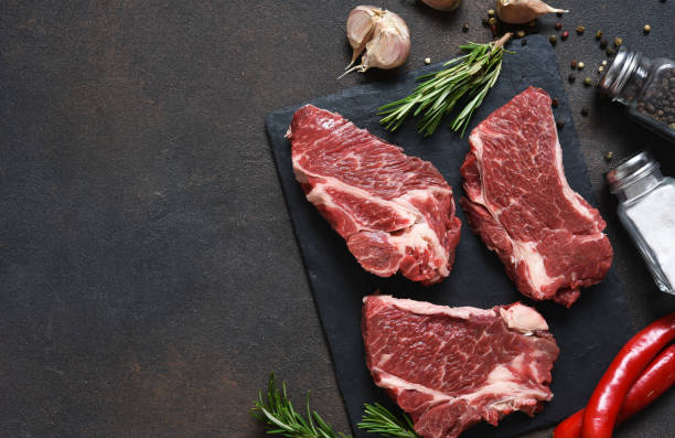 istock Raw marbled beef steak on a stone board. Spices, dishes. Top view flat lay with copy space. 1204165132