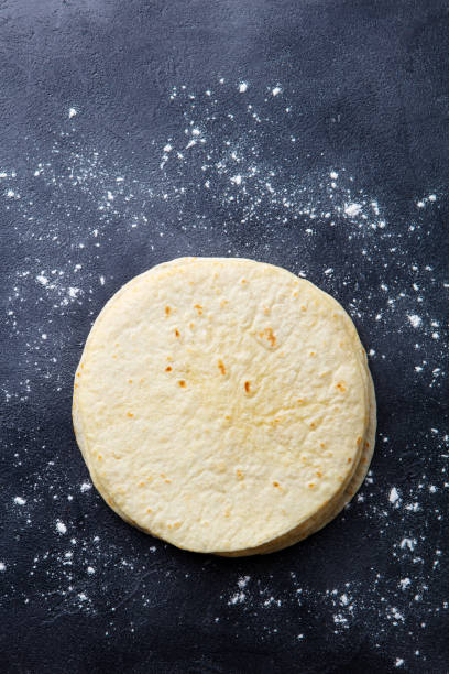 istock Tortillas, flat breads on dark grey background. Copy space. Top view. 1204165236