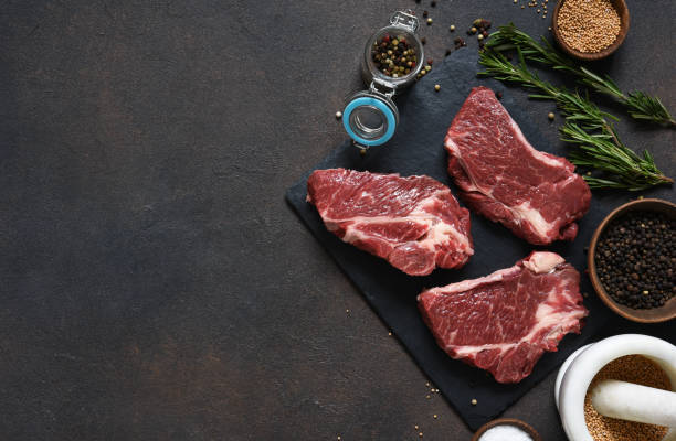 istock Raw marbled beef steak on a stone board. Spices, dishes. Top view flat lay with copy space. 1204165237