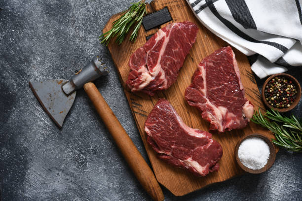 istock Raw beef steak beef steak on a wooden board with an ax. 1204165270