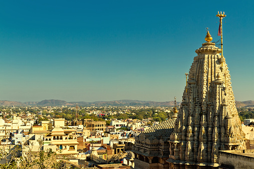 Arial view on buildings and beautiful Jagdish Temple in Udaipur, India against blue sky