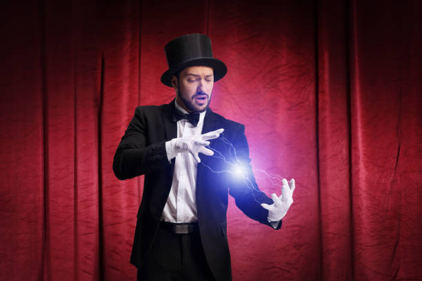 An elderly small-stage magician performs a playful hand gesture, presenting himself with subtle humor as a charming charlatan against a bright background.