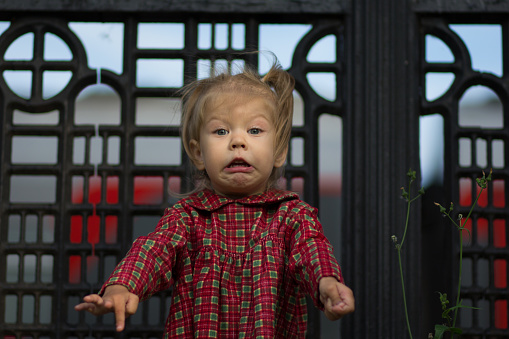 Funny face with grimace of caucasian child of two years old in summertime