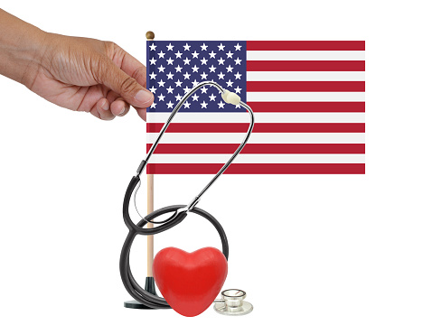 Red heart, Stethoscope and hand holding American flag on white background