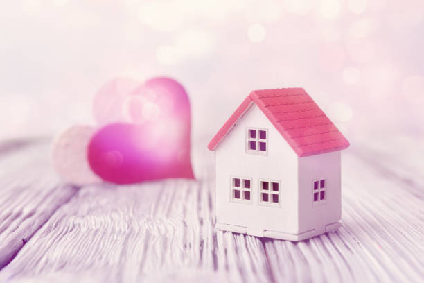 istock Toy house and two hearts on light defocused background. Selective focus. Valentines day concept 1204167595