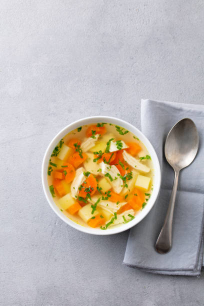 istock Chicken soup with vegetables in white bowl. Grey stone background. Copy space. Top view. 1204167691