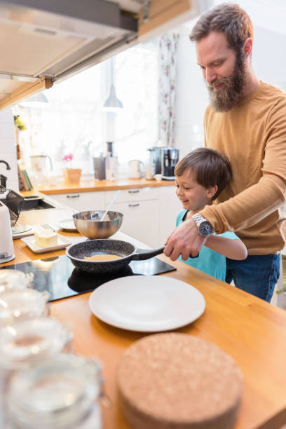 istock Father and son baking pancakes together 1204168488