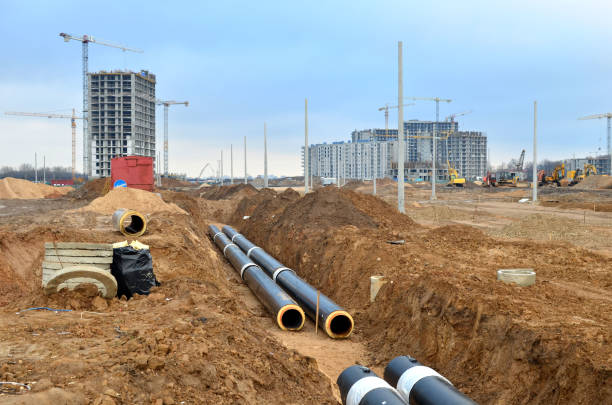 Laying underground storm sewers at a construction site Laying underground storm sewers at a construction site. Groundwater system for new residential buildings in the city. Installation of water main, sanitary sewer, storm drain systems in city. underground pipeline stock pictures, royalty-free photos & images