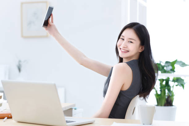 istock Business women use mobile phone self timer 1204172842