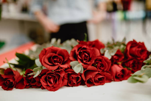 istock Red roses on white table in flower shop 1204176337