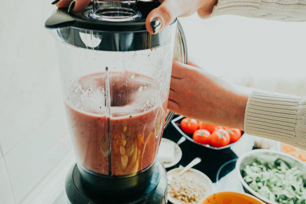 donna che fa frullato sano in cucina - blender foto e immagini stock