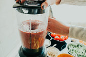 Woman making healthy smoothie in the kitchen