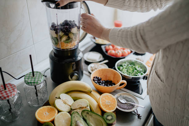 istock Woman making healthy smoothie in the kitchen 1204176450