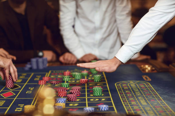 istock Croupier's hand gesture on the table with roulette chips. 1204179483