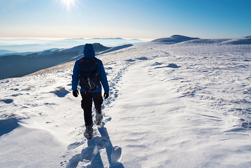 Rear view of the mountaineer hiking on the mountain.