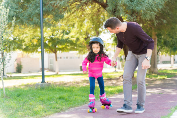 istock Girl Learning To Skate From Father 1204183256