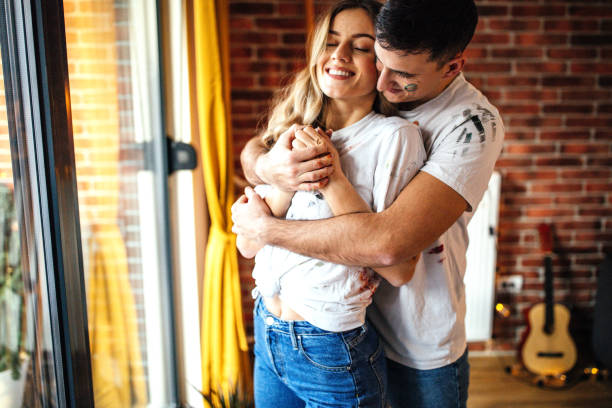 istock Couple embracing near window 1204183393