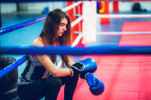 In a boxing ring Pretty teenage girl resting in a boxing ring. crossfit girl stock pictures, royalty-free photos & images