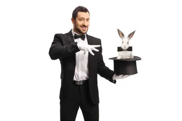 Magician making a magic trick with a rabbit in a hat isolated on white background