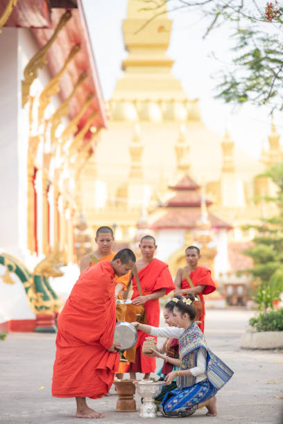 Luang Prabang, Laos - Aprial 28 2019 Buddhist monks collecting alms in Luang Pragang Laos. Every morning the monks walk through the streets of Luang Prabang too collect alms of local residents and tourists of the town.
