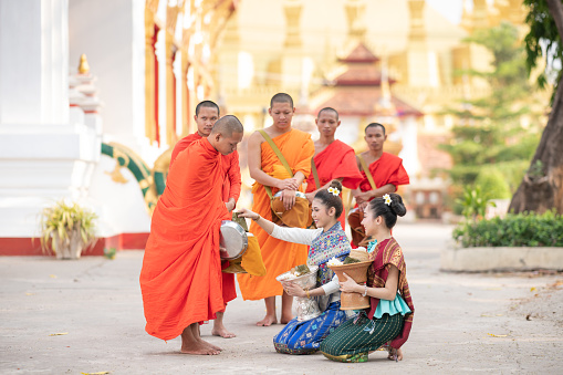 Luang Prabang, Laos - Aprial 28 2019 Buddhist monks collecting alms in Luang Pragang Laos. Every morning the monks walk through the streets of Luang Prabang too collect alms of local residents and tourists of the town.