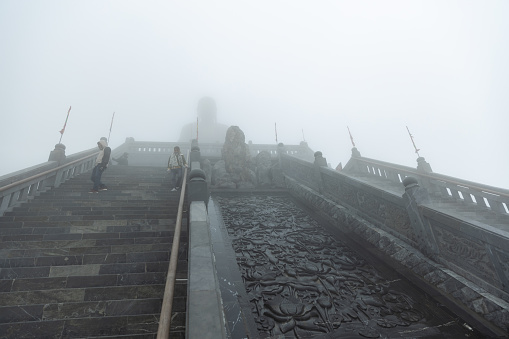 Lao Cai, Vietnam - December 30, 2019 : landscape view of staircase to buddhist temple located on Fansipan Sapa mountain with foggy.