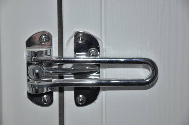 istock Silver door bar restictor fitted to a white door inside a house 1204186273
