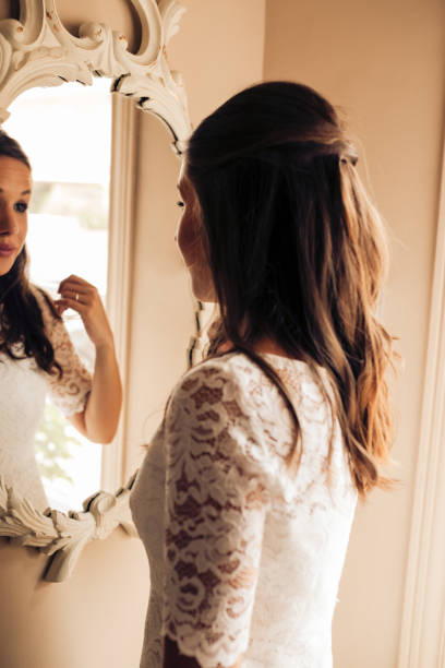 istock Bride before the wedding looking at herself and combing her hair in the mirror nervously. Important day. Wedding and marry concept. 1204187521