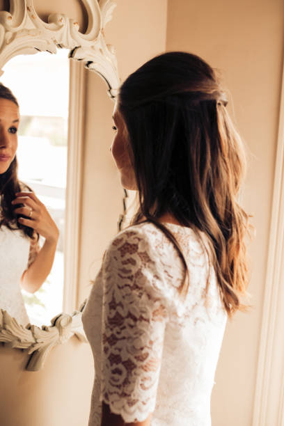 istock Bride before the wedding looking at herself and combing her hair in the mirror nervously. Important day. Wedding and marry concept. 1204187669