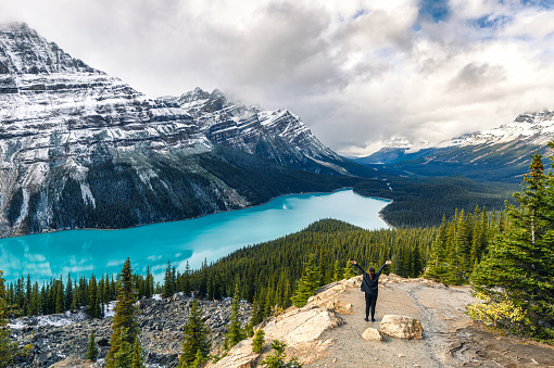 Scenery of Peyto lake resemble of fox with woman traveler raised arm in Banff national park at Canada