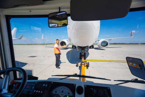 istock Ground crew towing airplane to the runway 1204189273