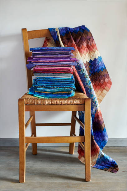 istock Stack of fabrics lying on chair and quilt top made in bargello style 1204189878