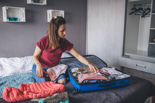 istock Young woman packing suitcase for vacation 1204190877