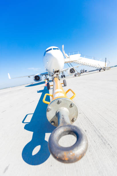 Close up of towing hook attached to plane nose. Aircraft in the background.