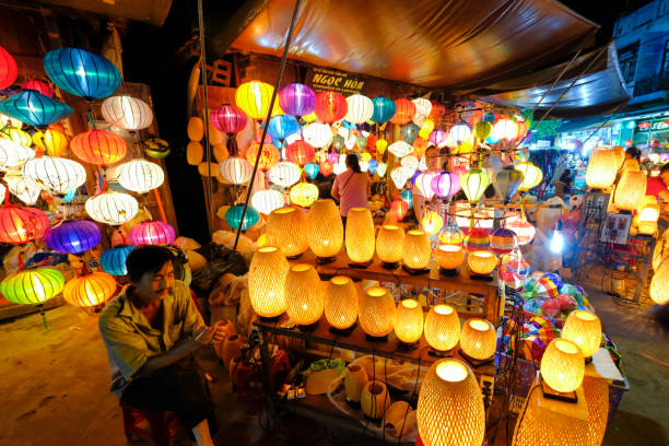 człowiek sprzedaje kolorowe tradycyjne wietnamskie latarnie na nocnym targu w hoi an - vietnam hoi an traditional culture travel zdjęcia i obrazy z banku zdjęć