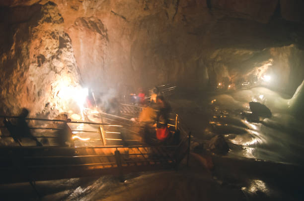 istock Unrecognizable tourists walking down the stairs in a cave 1204192479