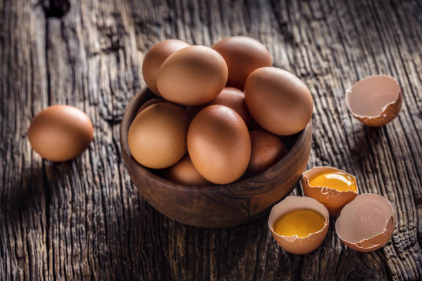 istock Chicken eggs in wooden bowl on rustic oak table 1204192673