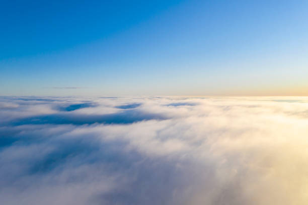 Aerial view White clouds in blue sky. Top view. View from drone. Aerial bird's eye view. Aerial top view cloudscape. Texture of clouds. View from above. Sunrise or sunset over clouds Aerial view White clouds in blue sky. Top view. View from drone. Aerial bird's eye view. Aerial top view cloudscape. Texture of clouds. View from above. Sunrise or sunset over clouds stratosphere airplane cloudscape mountain stock pictures, royalty-free photos & images