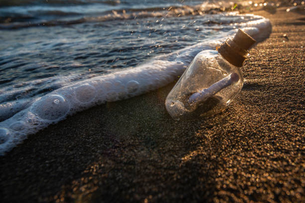 istock Bottle with a message in the sea at sunset 1204196493