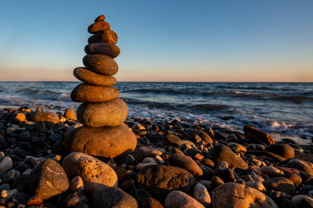 Pyramid of stones on the beach at sunset,