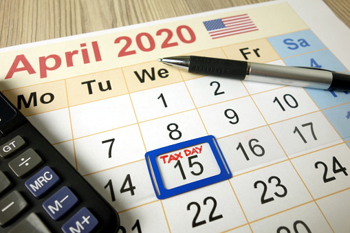 Calendar on office desk showing tax day for filling - April 15 2020, finance concept