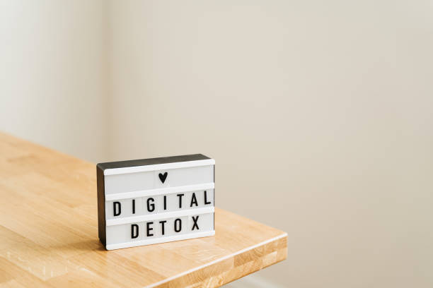 Digital detox day. Lightbox on wooden background and white walls. Gadget ban stock photo