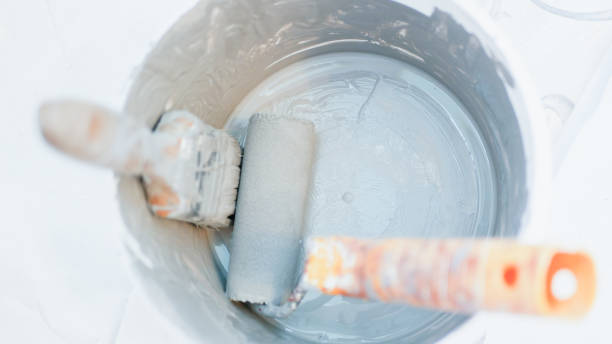 istock paint brush gray paint. plastic container for paint. home repairs 1204205185