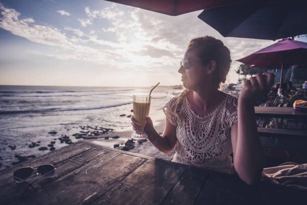 istock Female drinking mango juice at sunset. 1204205758