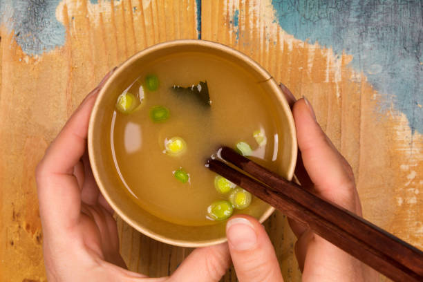 istock Woman eating miso soup in eco cup. 1204207050