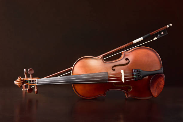 violon reflété sur la table en bois et le fond brun de gradient - classical music music musical instrument brown photos et images de collection