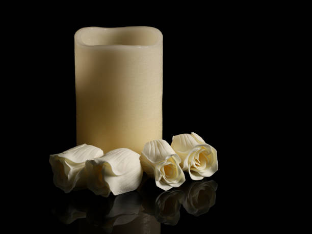 istock White roses and candle on black background 1204213668