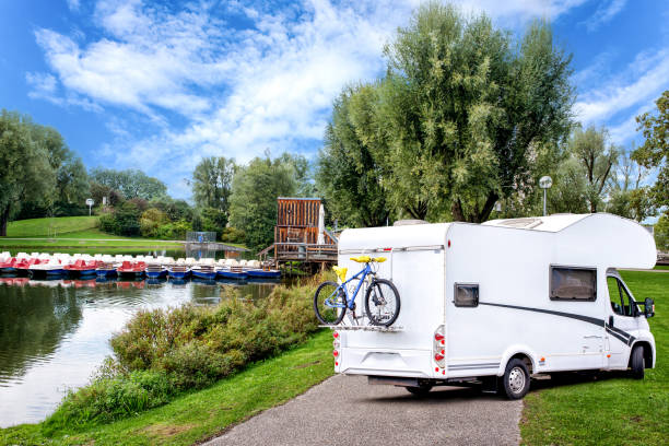 istock Caravan van with bicycle on lawn in park. 1204218902
